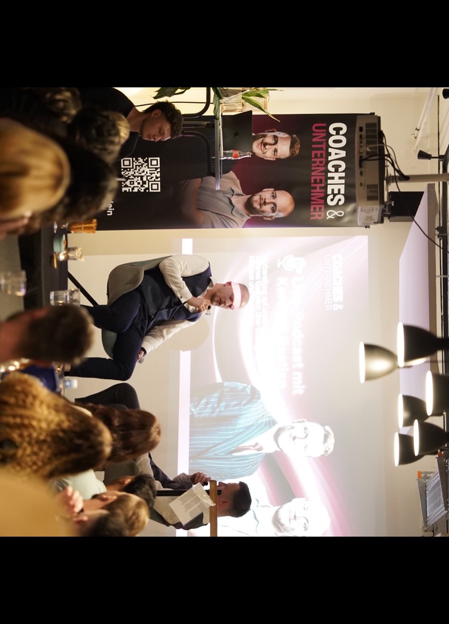Kenneth Beller speaking on stage at a coaches and entrepreneurs event